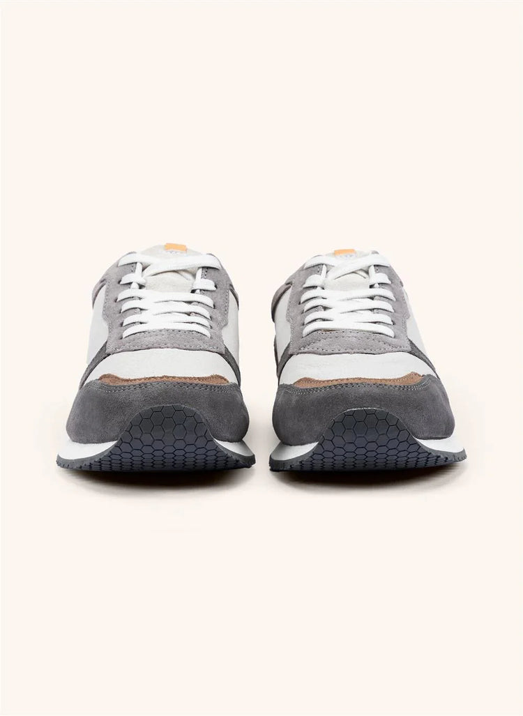 Gråvita herrsneakers i mocka och textil med vita skosnören, set framifrån på ljus bakgrund