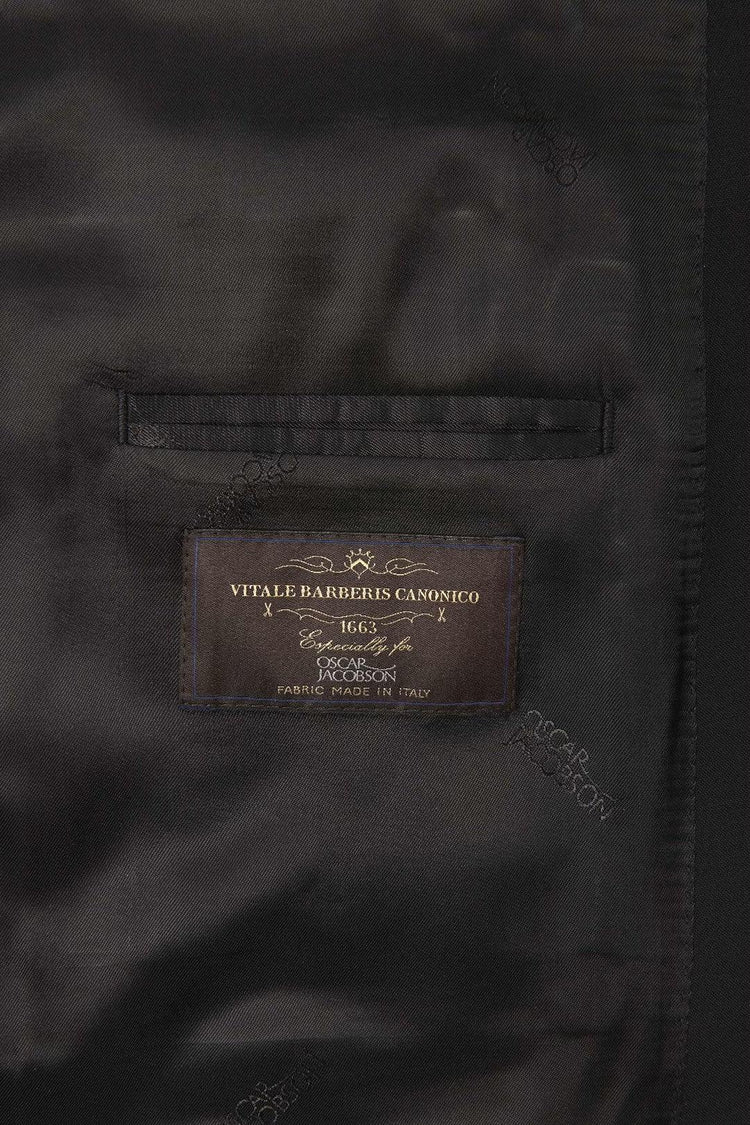 Närbild på svart kavajfoder med etikett från Vitale Barberis Canonico, tyg tillverkat i Italien.