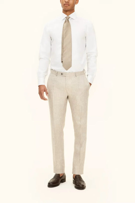 Herr i ljusa trenchbeige byxor, vit skjorta och slips, klassisk och stilren look