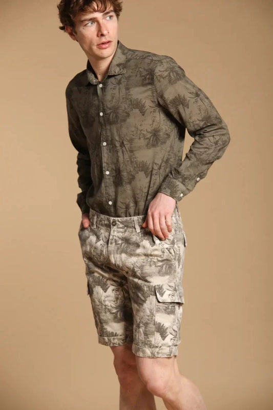 Man i grönmönstrad skjorta och beige shorts med palmtryck, herrmode sommarstil