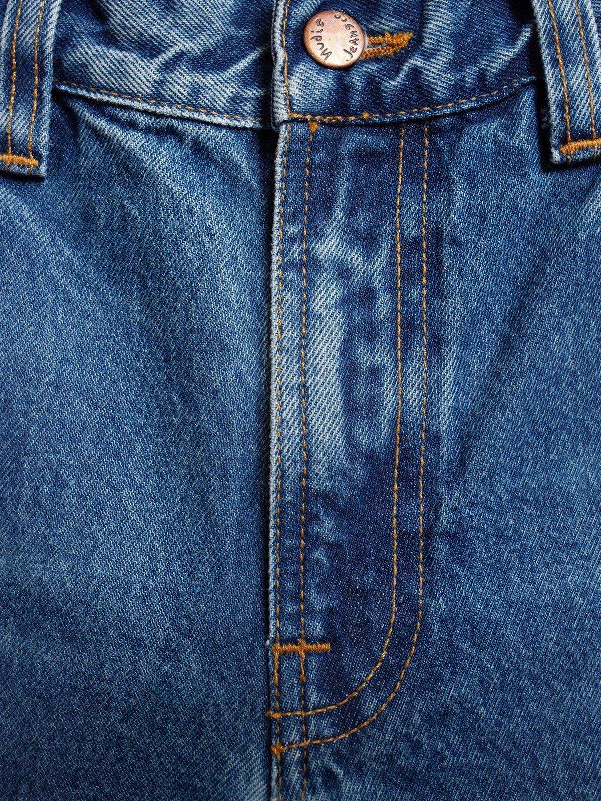 Närbild på blå herrjeans med synliga sömmar och knapp, klassiska denimbyxor