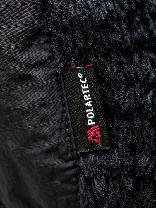 Detalj närbild av svart herr fleecejacka med Polartec-etikett och struktur.