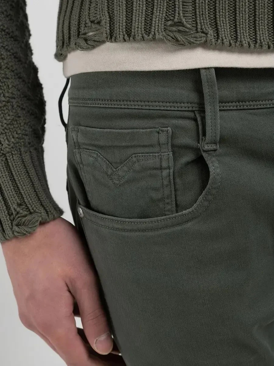 Närbild på gröna herrbyxor i denim med framficka och bälteshållare