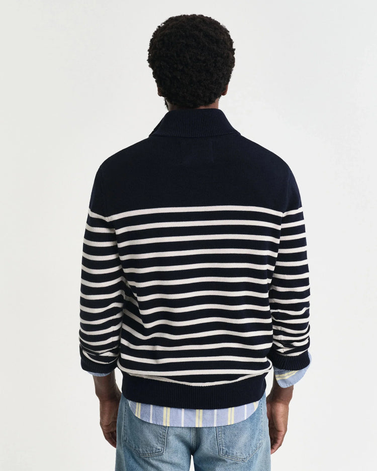 Man med ryggen mot kameran i marinblå och vitrandig tröja och blå jeans