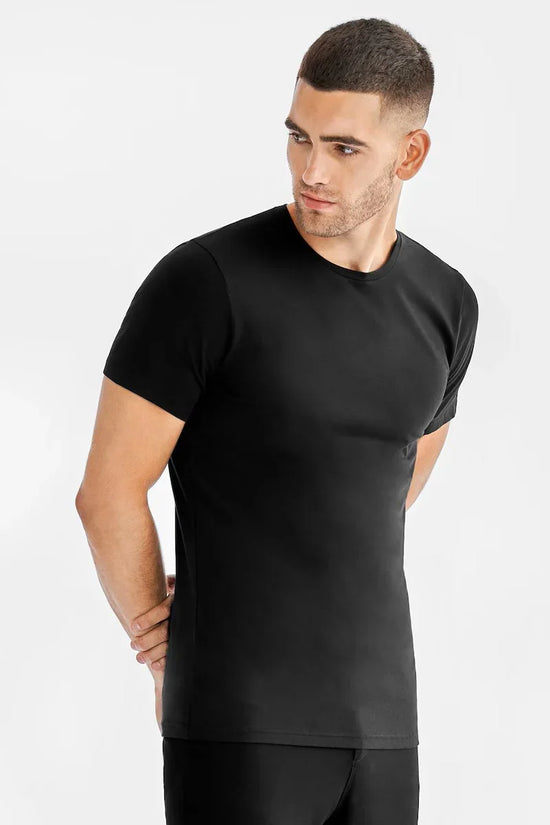 Manlig modell i svart t-shirt med rund hals, klassisk herrmode mot vit bakgrund.