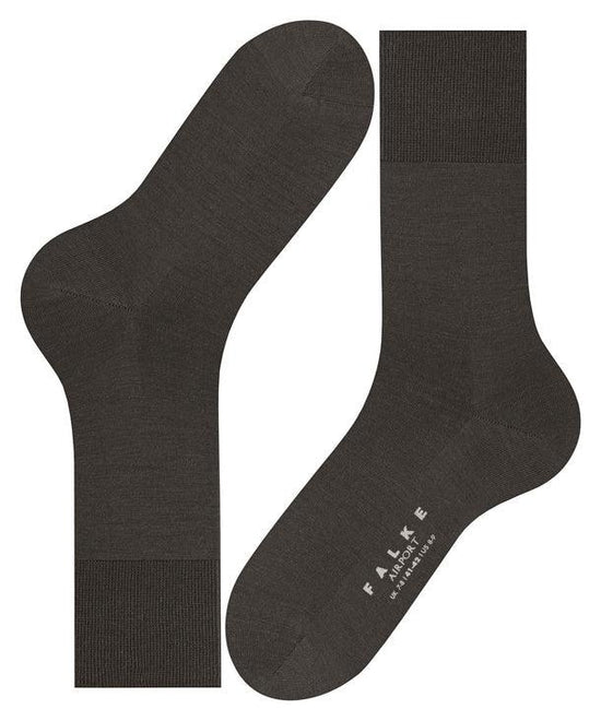 Mörkgrå herrstrumpor i merinoull, klassisk design, texten FALKE Airport synlig på foten