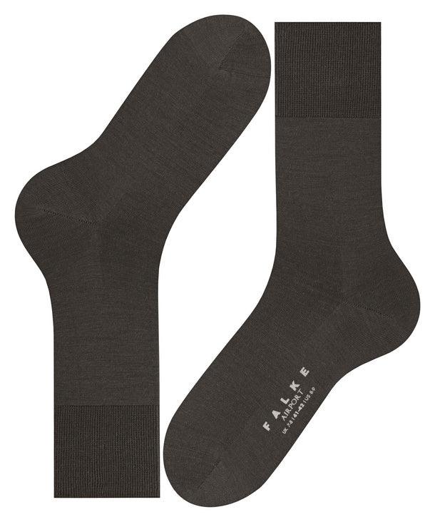 Mörkgrå herrstrumpor i merinoull, klassisk design, texten FALKE Airport synlig på foten
