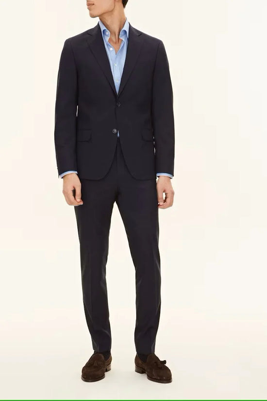 Herr i mörkblå kostym och ljusblå skjorta, klassiska herrkläder för vardag och fest.