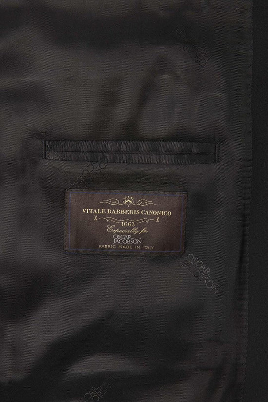 Närbild på svart kavajfoder med etikett från Vitale Barberis Canonico, tyg tillverkat i Italien.
