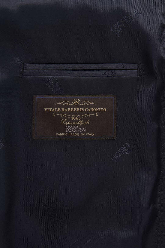 Närbild innerfoder på mörk blå kavaj med etikett Vitale Barberis Canonico, herrkläder.
