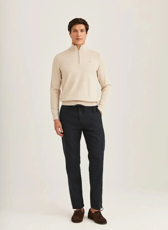Man i beige stickad tröja och mörkblå linnabyxor, herrmode, neutral bakgrund