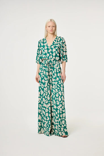 Grön och vit mönstrad jumpsuit med v-ringning och knyt i midjan dam
