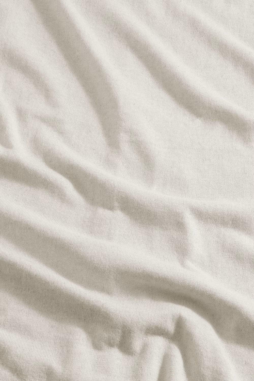 Nära bild på ljusbeige bomullstyg med synlig struktur, herrkläder, klassiskt material