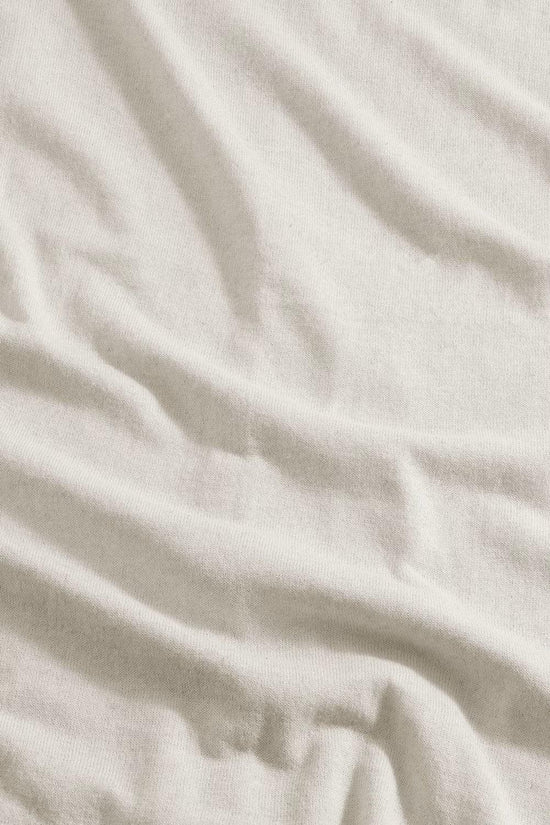 Nära bild på ljusbeige bomullstyg med synlig struktur, herrkläder, klassiskt material