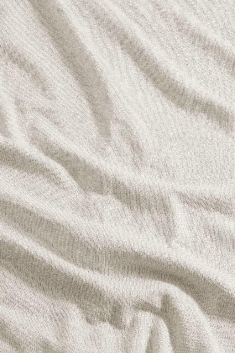 Nära bild på ljusbeige bomullstyg med synlig struktur, herrkläder, klassiskt material