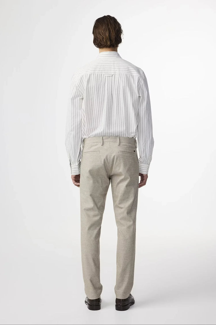 Bakre vy av herrkostymbyxor i beige, klassiskt snitt, på modell i skjorta.