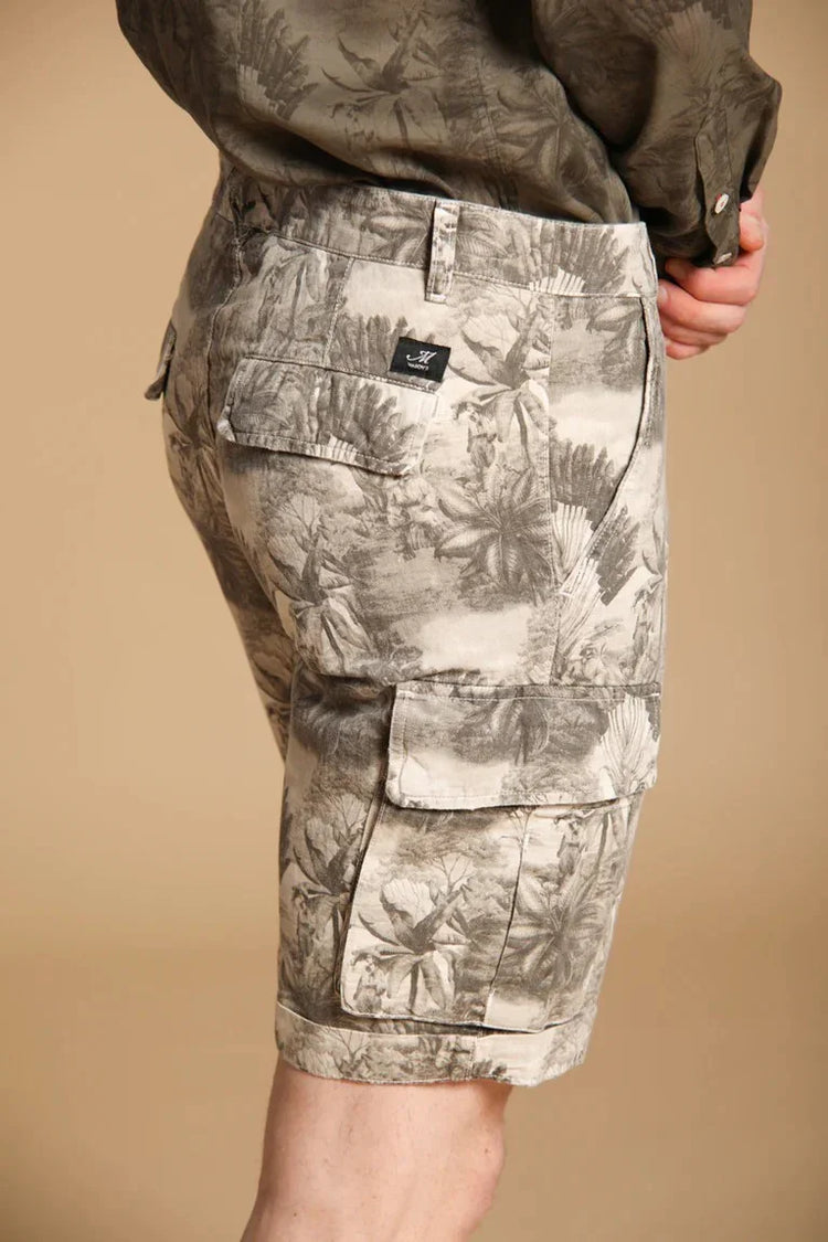 Beige herrshorts med tropiskt mönster och cargofickor, bakifrån mot neutral bakgrund