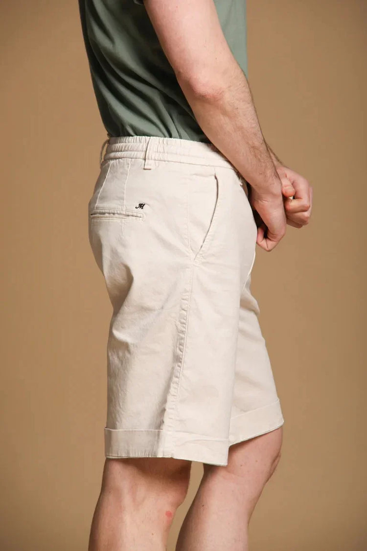 Beige herrshorts i bomull, sidoficka och avslappnad passform mot beige bakgrund