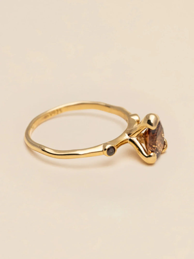 Elegant guldring med brun sten och smal design, minimalistiskt herraccessoar
