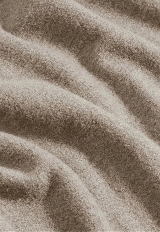 Ulltyg herr jacka – närbild av mjukt beige ullmaterial, klassiskt herrmode