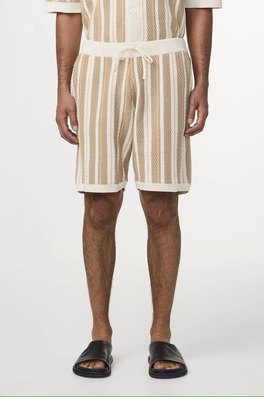 Herr i beige och vita randiga shorts med dragsko och svarta sandaler, sommarkläder