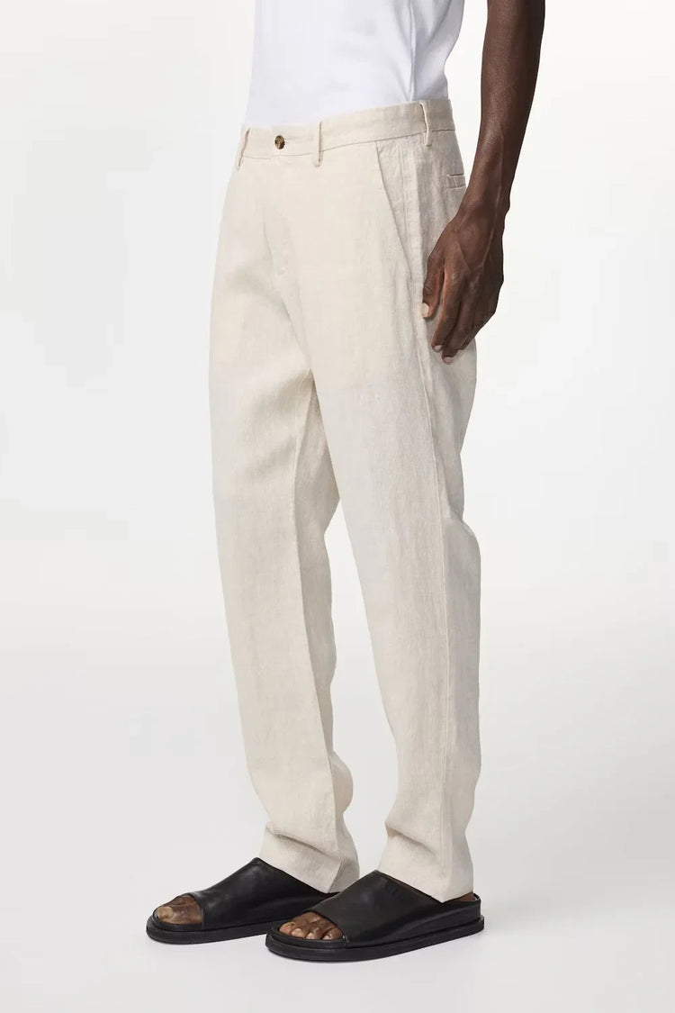Beige linnebyxor herr, klassiskt snitt, bärs med vit skjorta och svarta sandaler