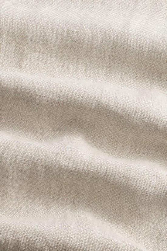 Närbild på beige linnetyg med synlig struktur och mjuka veck, herrkläder material