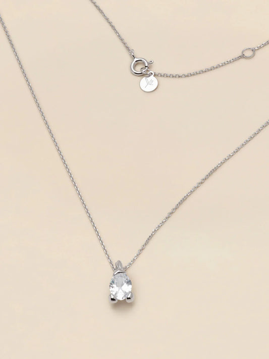Elegant silverhalsband med gnistrande klar stenberlock på ljus bakgrund