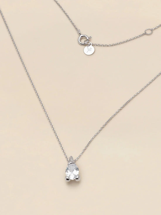 Elegant silverhalsband med gnistrande klar stenberlock på ljus bakgrund