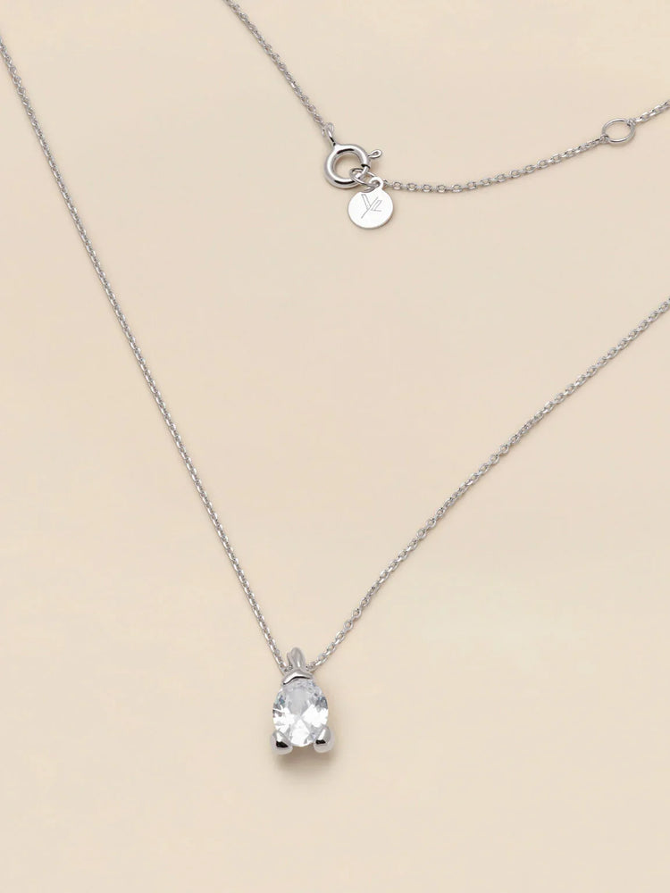Elegant silverhalsband med gnistrande klar stenberlock på ljus bakgrund