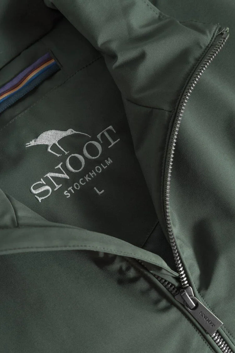 Närbild på grön herrjacka med dragkedja och broderad logotyp från Snoot Stockholm