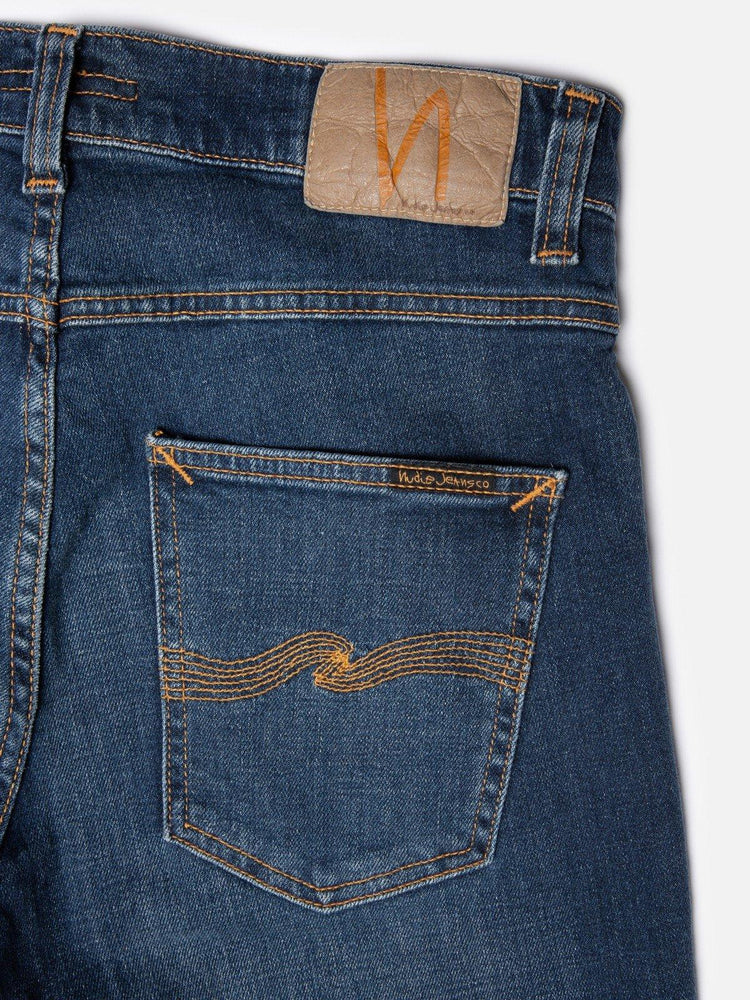 Blå herrjeans med bakficka och dekorativ gul söm, klassisk denimstil.