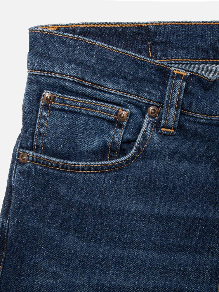 Närbild av blå herrjeans med klassisk femficksdesign och kontrastsömmar