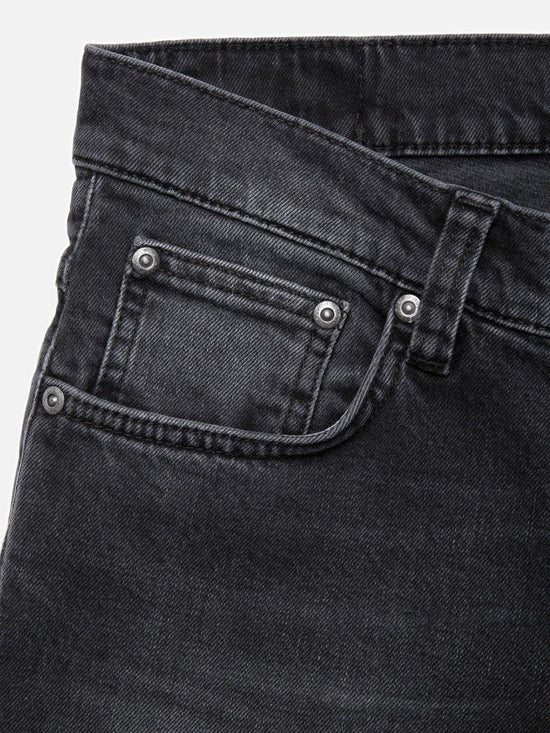 Närbild av svart herrjeans med fickdetaljer och nitar, klassiska herrkläder
