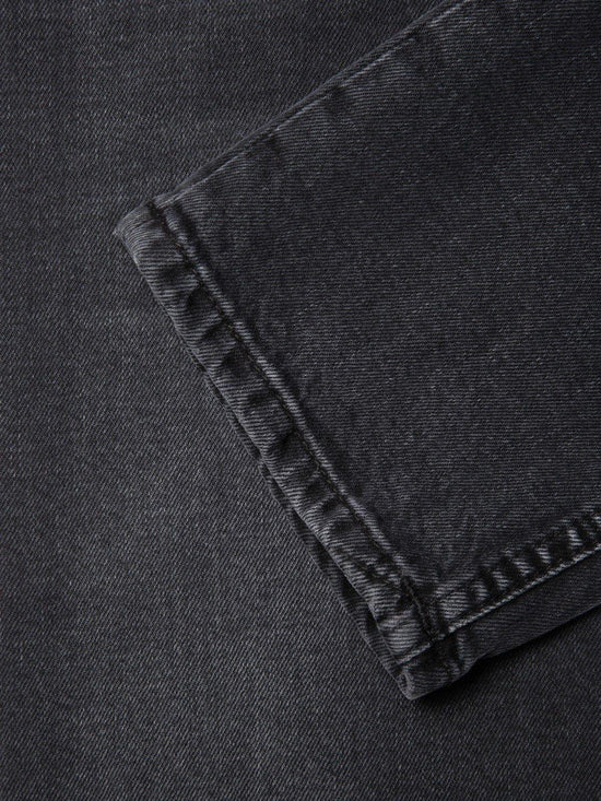 Närbild på benavslut av mörkgrå herrjeans i denim, klassiska herrkläder.