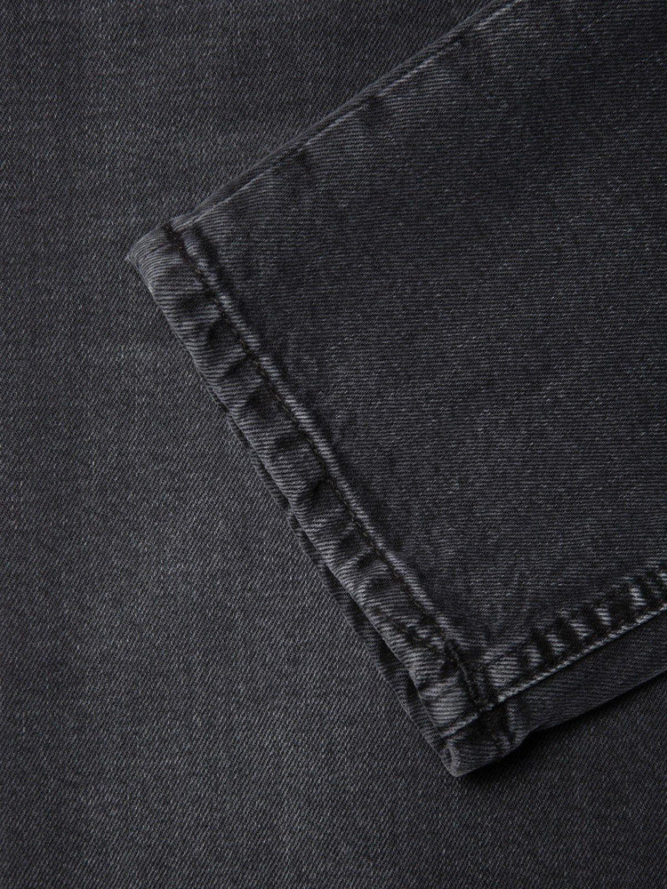 Närbild på benavslut av mörkgrå herrjeans i denim, klassiska herrkläder.