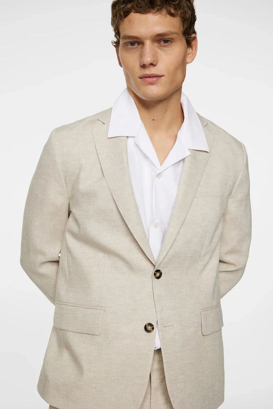Man i ljusbeige kostym och vit skjorta, klassiskt herrmode, neutral bakgrund