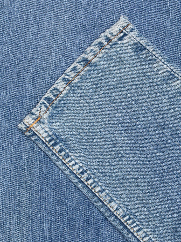 Närbild på ljusblå herrjeans i vintage denim med kontrasterande söm