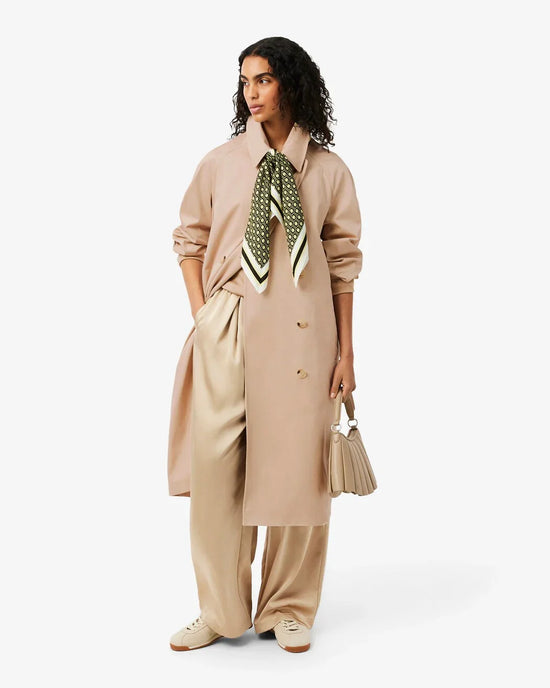 Beige trenchcoat, vida byxor, grön mönstrad scarf, damväska, sneakers