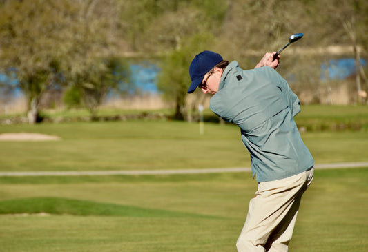 Blå golfmössa herr, ljusgrön golfjacka och beige golfbyxor