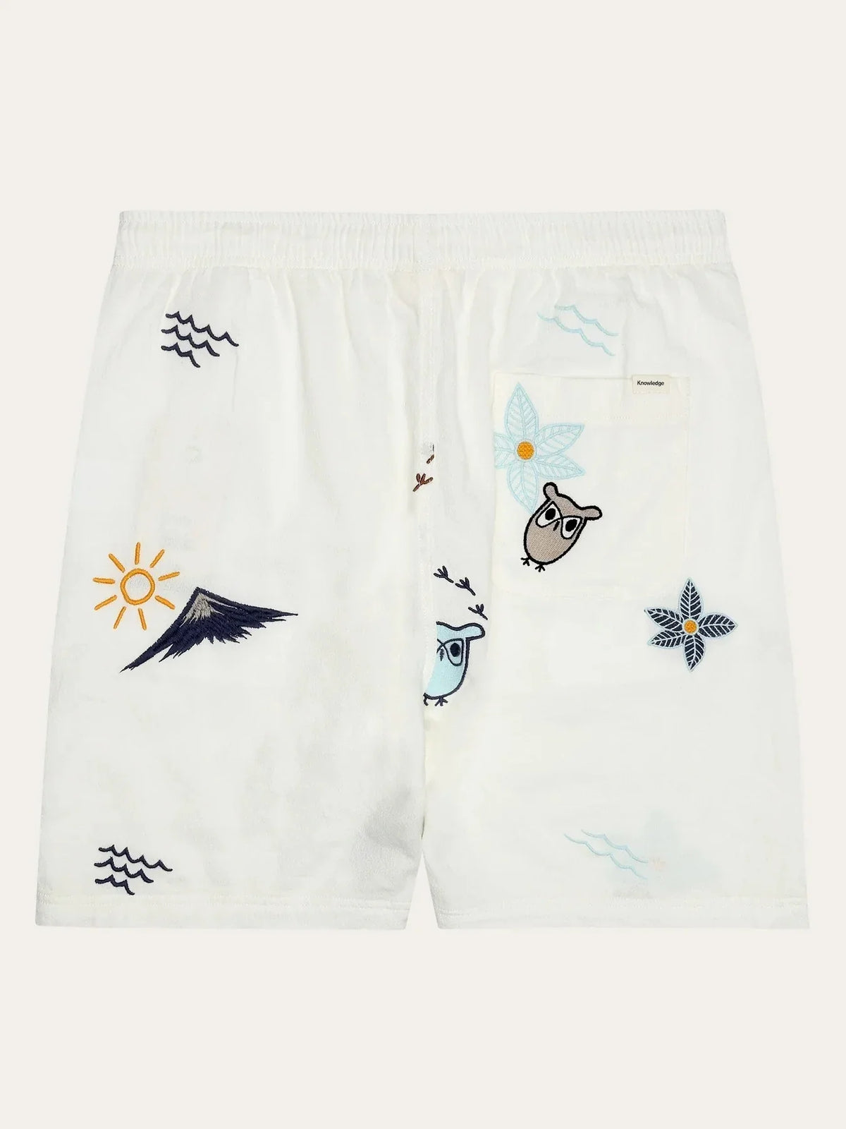 Vita herrshorts med broderade motiv av ugglor, blommor, vågor och solen, elastisk midja