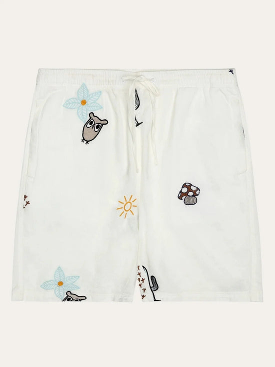 Vita herrshorts med broderade motiv av uggla, blomma, sol och svamp, dragsko i midjan.