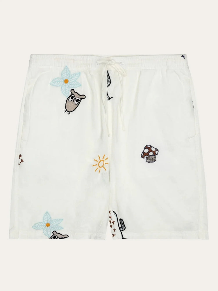 Vita herrshorts med broderade motiv av uggla, blomma, sol och svamp, dragsko i midjan.