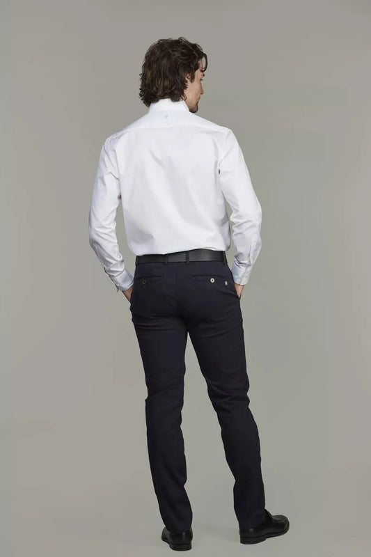 Man i mörkblå stretch-chinos och vit skjorta, bakifrån, klassiskt herrmode