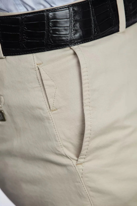 Detaljbild av beige herrchinos med hög stretch och svart läderbälte
