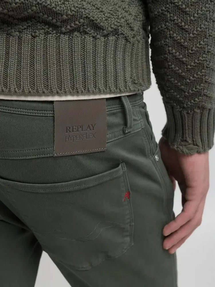 Gröna stretchjeans för herr med stickad tröja, detaljbild på bakficka och etikett.