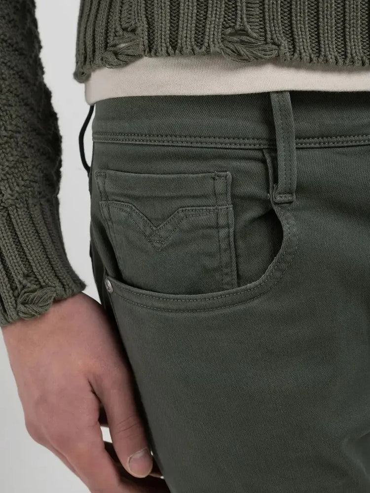 Närbild på gröna herrbyxor i denim med framficka och bälteshållare