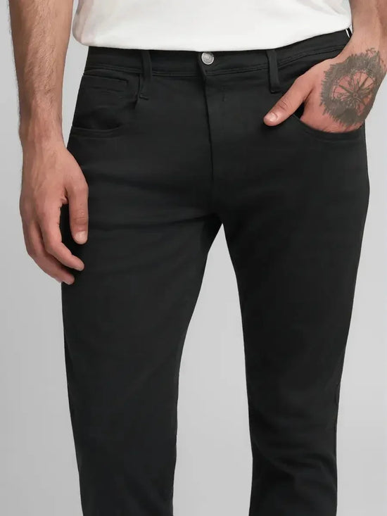 Herr i svarta jeans med fem fickor och vit t-shirt, klassisk stil herrmode