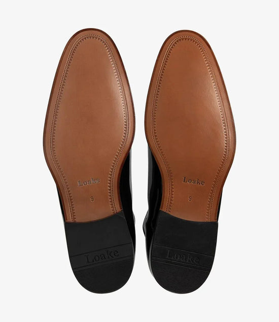 Bruna lädersulor på eleganta herrskor, synliga Loake-detaljer och svarta klackar