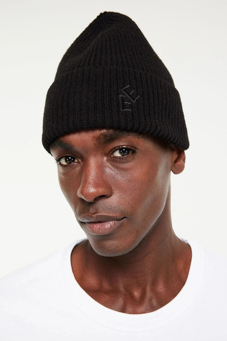 Rib hat herr mössa – svart stickad mössa på manlig modell med diskret broderad logga